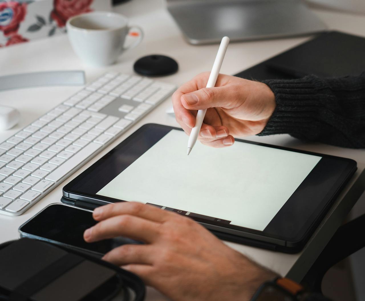 creative Designer working with a tablet and stylus in a modern workspace setup.