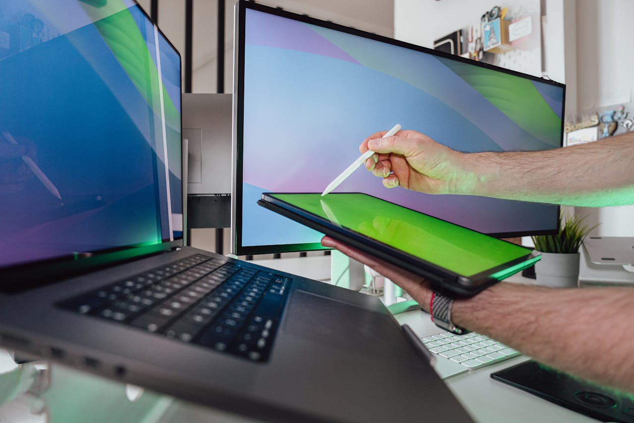 Mastering the First Impression: Your intriguing post title goes here A person using a stylus on a tablet in a tech-savvy workspace with dual monitors