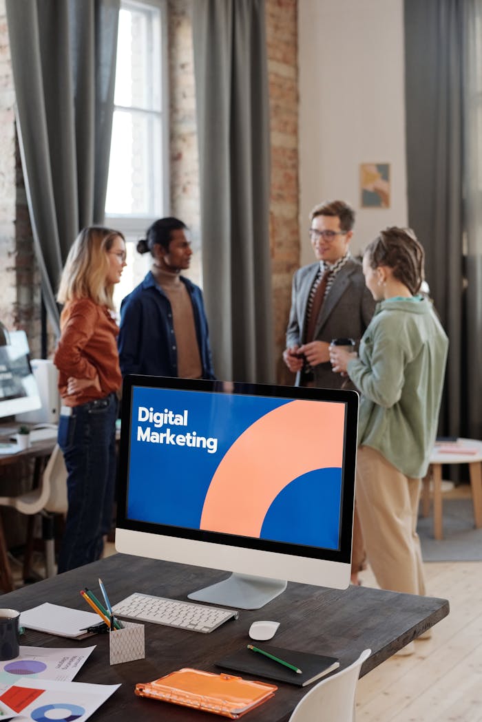 brand-03 Business team engaged in a digital marketing discussion in a modern office setting.